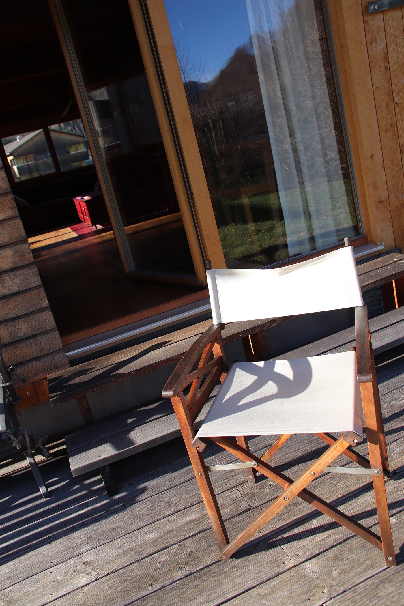Terrasse mit Holzdeck und Regiestuhl